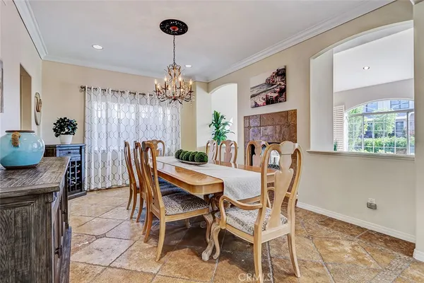 a dining room with furniture a chandelier and window