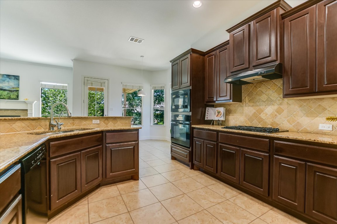 3104 Herradura Drive Cedar Park, TX 78641 - Photo 8 of 20 a kitchen with stainless steel appliances granite countertop a sink stove and refrigerator