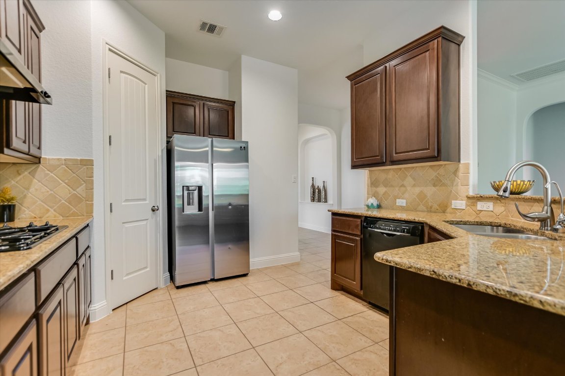 3104 Herradura Drive Cedar Park, TX 78641 - Photo 9 of 20 a kitchen with stainless steel appliances granite countertop a refrigerator and a stove top oven