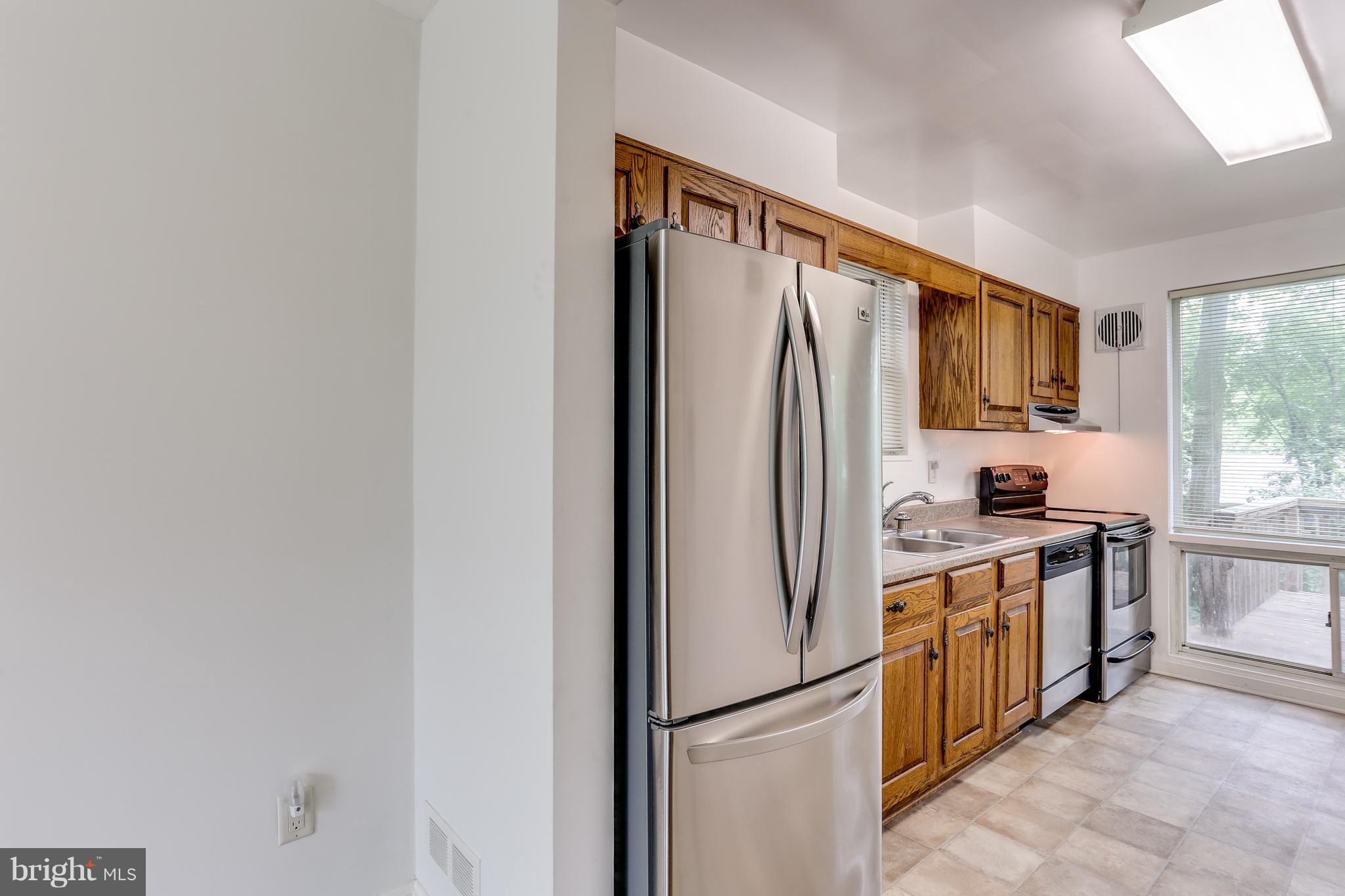 12714 Helen Road Silver Spring, MD 20906 - Photo 6 of 19 a kitchen with stainless steel appliances granite countertop a refrigerator a stove a sink a microwave and cabinets