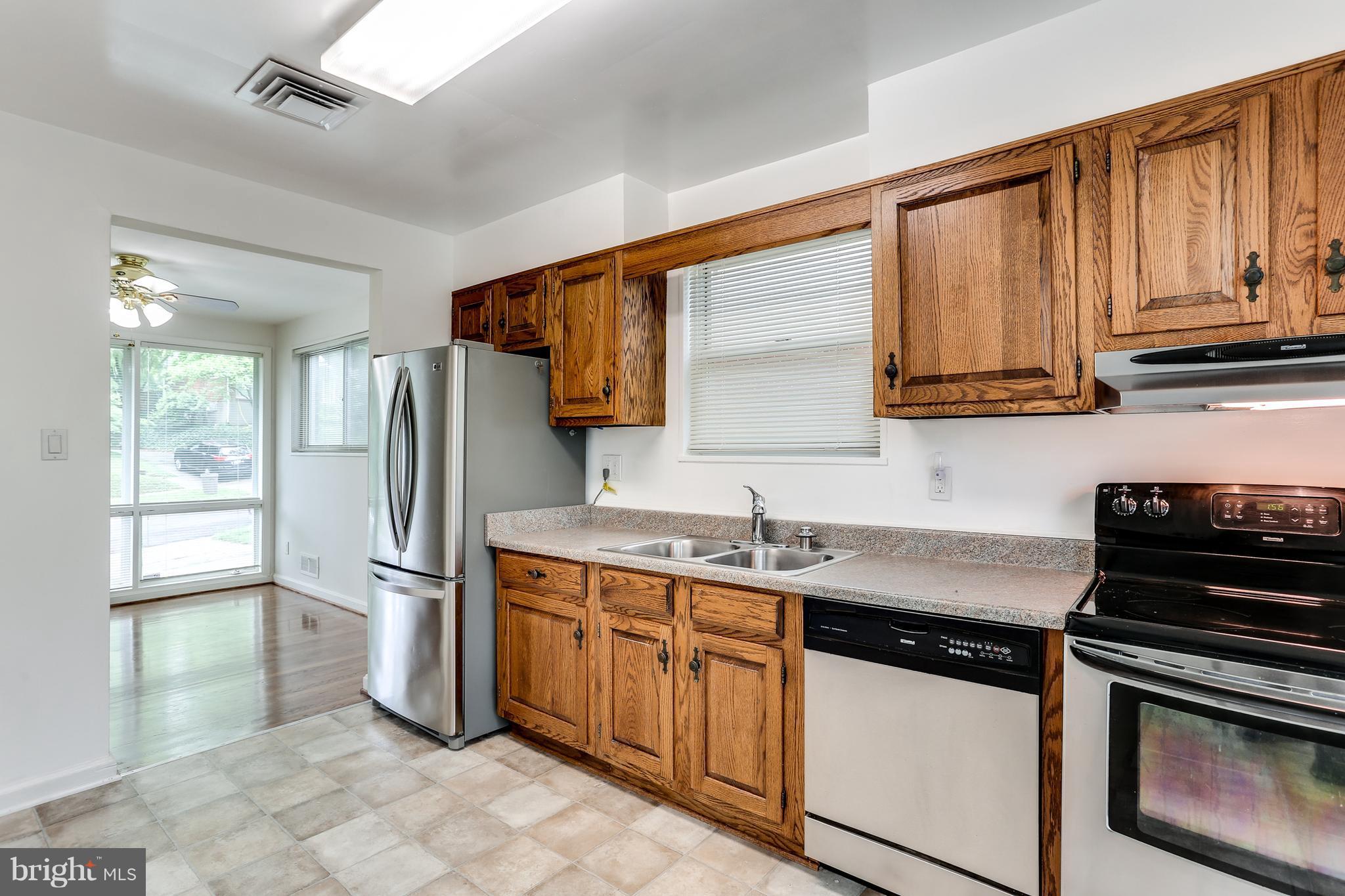 12714 Helen Road Silver Spring, MD 20906 - Photo 8 of 19 a kitchen with kitchen island granite countertop a sink stove and refrigerator