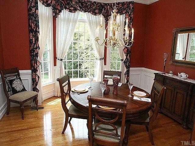 2332 Primrose Valley Court Raleigh, NC 27613 - Photo 5 of 12 The elegant dining room features hardwood flooring, a bay window, crown molding, and picture frame wainscoting.