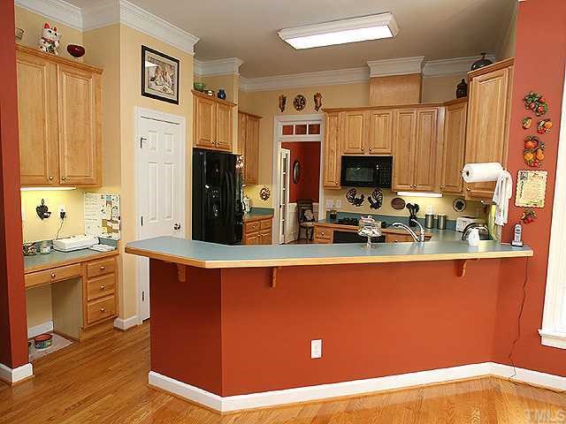 2332 Primrose Valley Court Raleigh, NC 27613 - Photo 6 of 12 Spacious kitchen has a built-in desk, pantry, crown molding, transom window, and a breakfast bar that provides space for 6 bar stools.