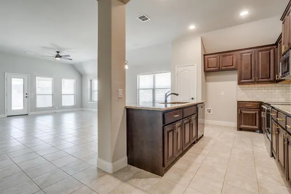 a kitchen with stainless steel appliances granite countertop a stove sink and cabinets