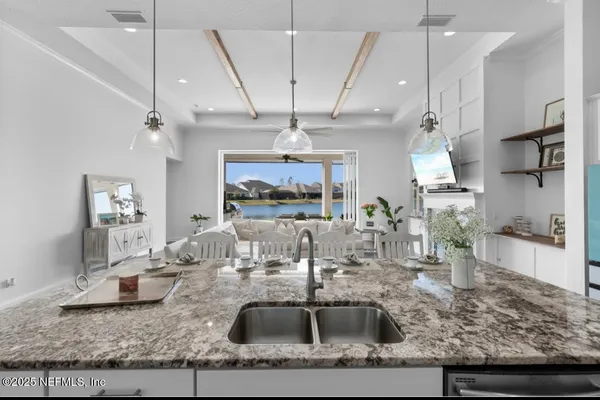 a kitchen with kitchen island granite countertop a sink a counter top space cabinets and stainless steel appliances