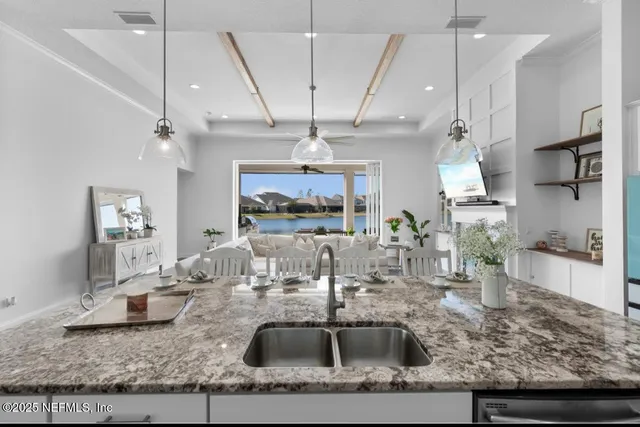 a kitchen with kitchen island granite countertop a sink a counter top space cabinets and stainless steel appliances