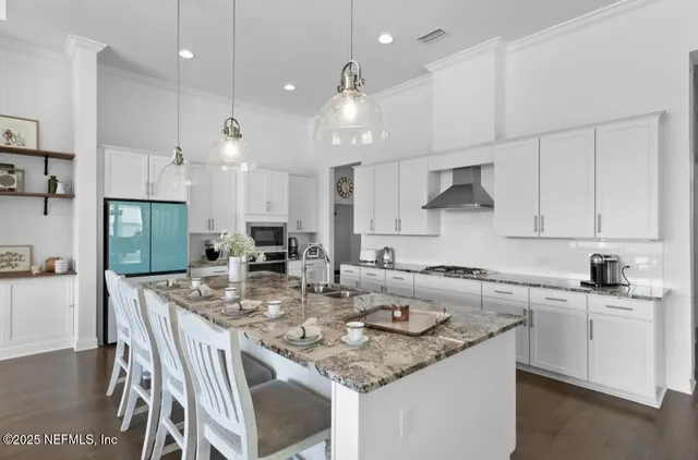 a kitchen with kitchen island granite countertop a sink a center island and cabinets