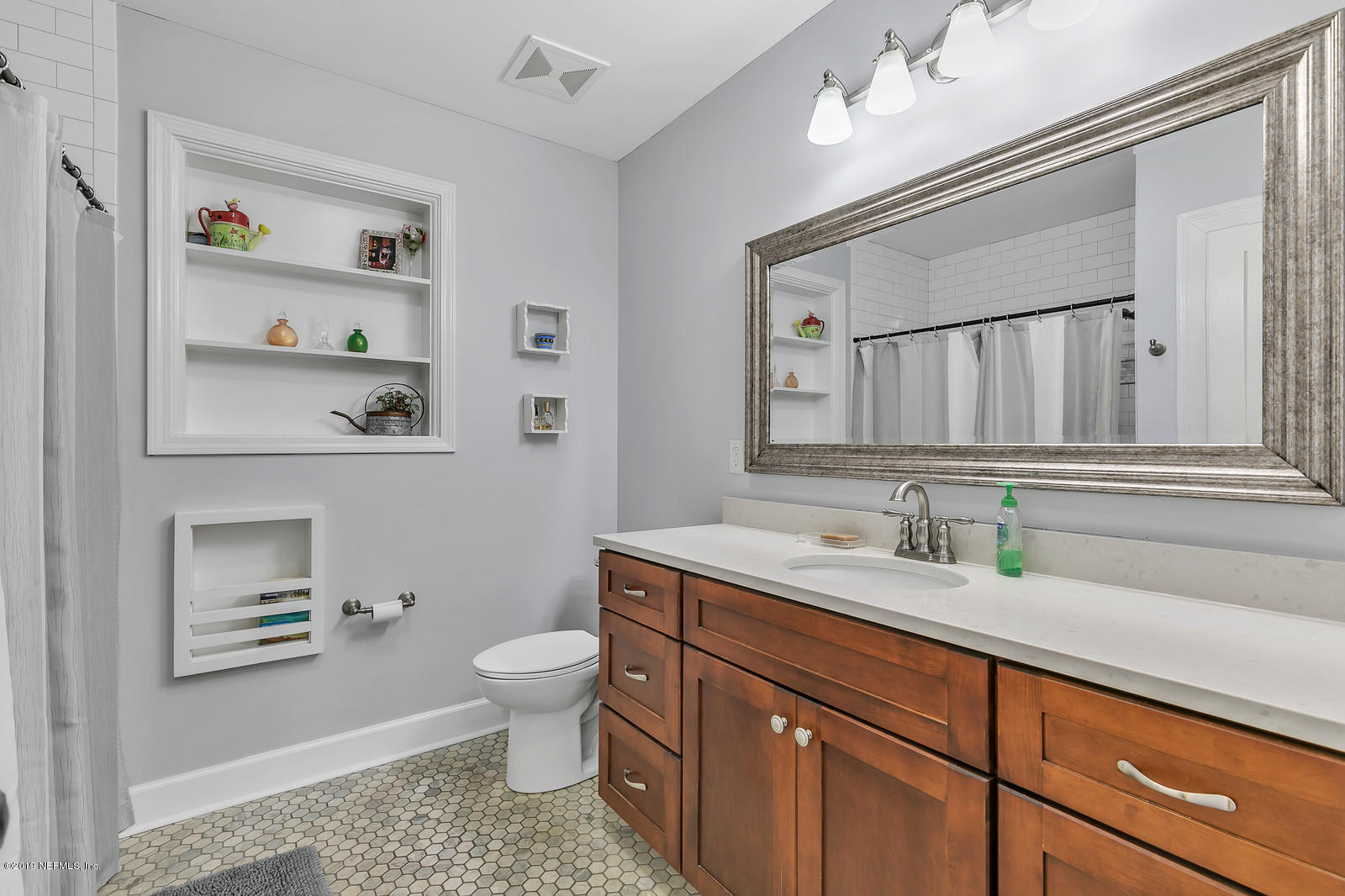 1425 Nicholson Road Jacksonville, FL 32207 - Photo 29 of 45 a bathroom with a granite countertop sink a toilet and a mirror