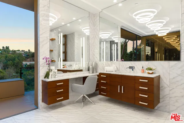 a view of a hallway with kitchen and chandelier