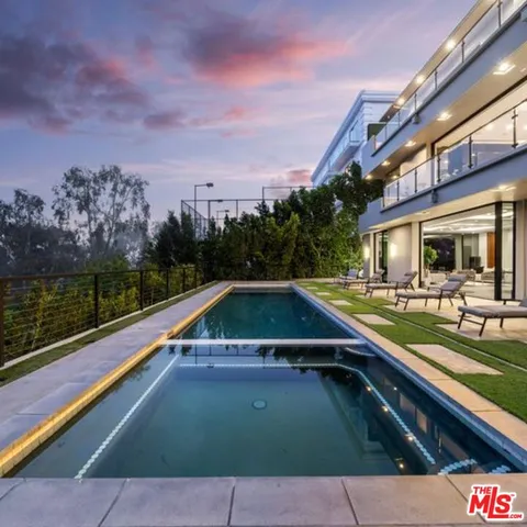 a view of a swimming pool with a lounge chair and a big yard