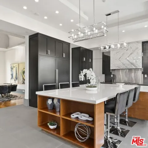 a kitchen that has a lot of cabinets in it and stainless steel appliances