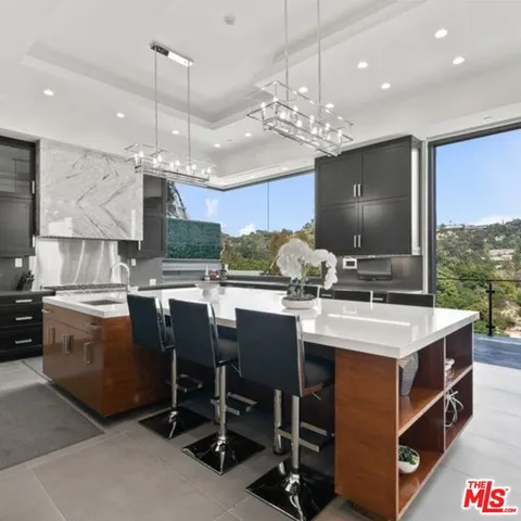 a kitchen with stainless steel appliances granite countertop a sink a stove and a refrigerator