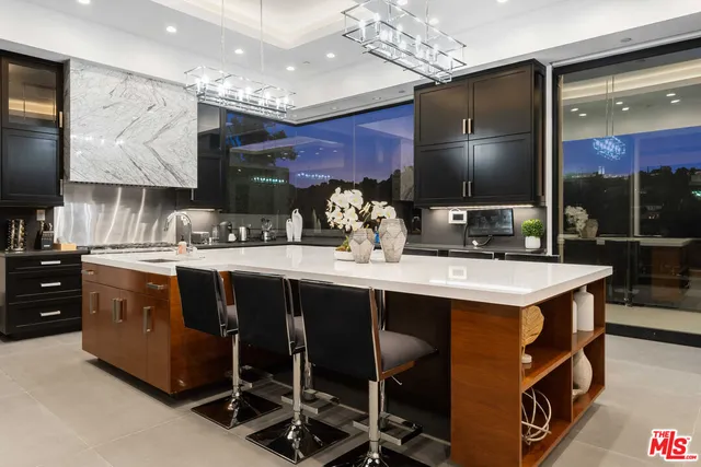 a kitchen with kitchen island granite countertop a sink counter top space and stainless steel appliances