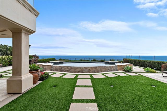 a swimming pool view with a seating space and a garden view