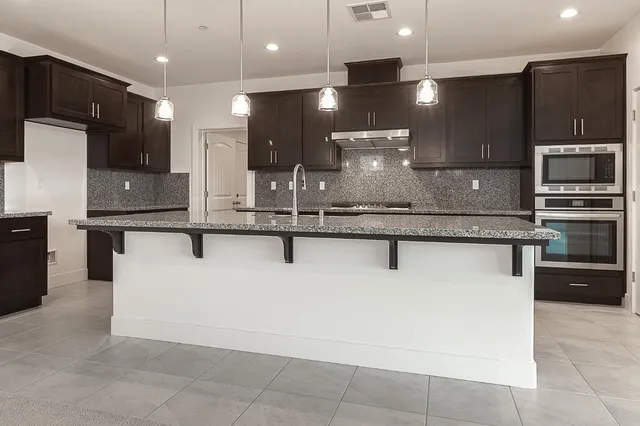 a kitchen with a sink a counter space appliances and cabinets