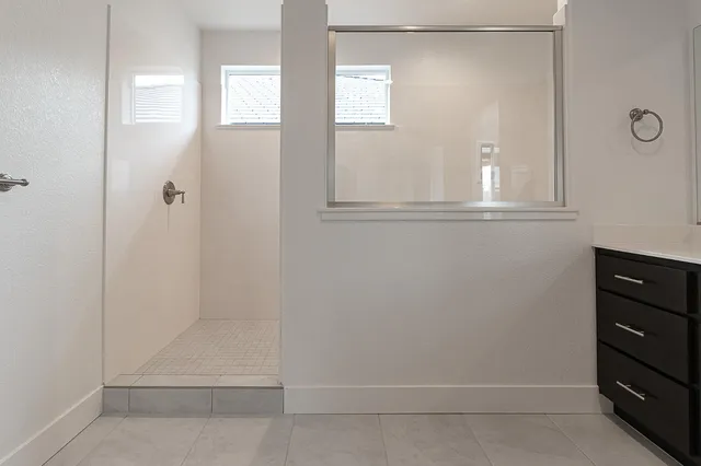 a spacious bathroom with a granite countertop double vanity sink mirror and bathtub