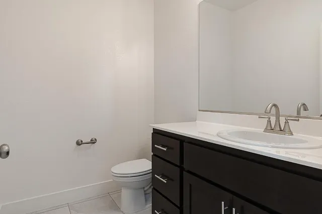 a bathroom with a granite countertop toilet sink and mirror
