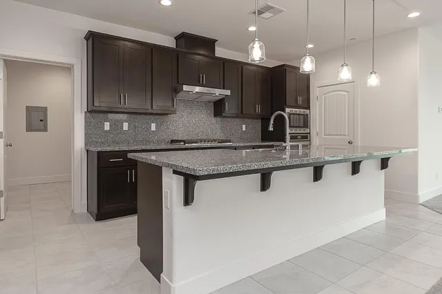 a kitchen with kitchen island a sink stainless steel appliances and cabinets