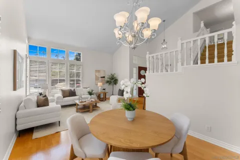 a living room with dining table and a chandelier