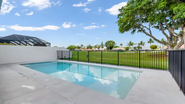 a view of a swimming pool with a yard and plants