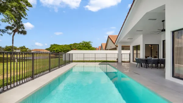 a view of a house with backyard and sitting area