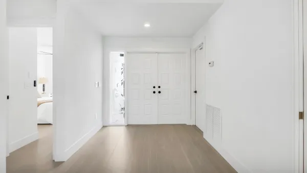 a view of a hallway with wooden floor