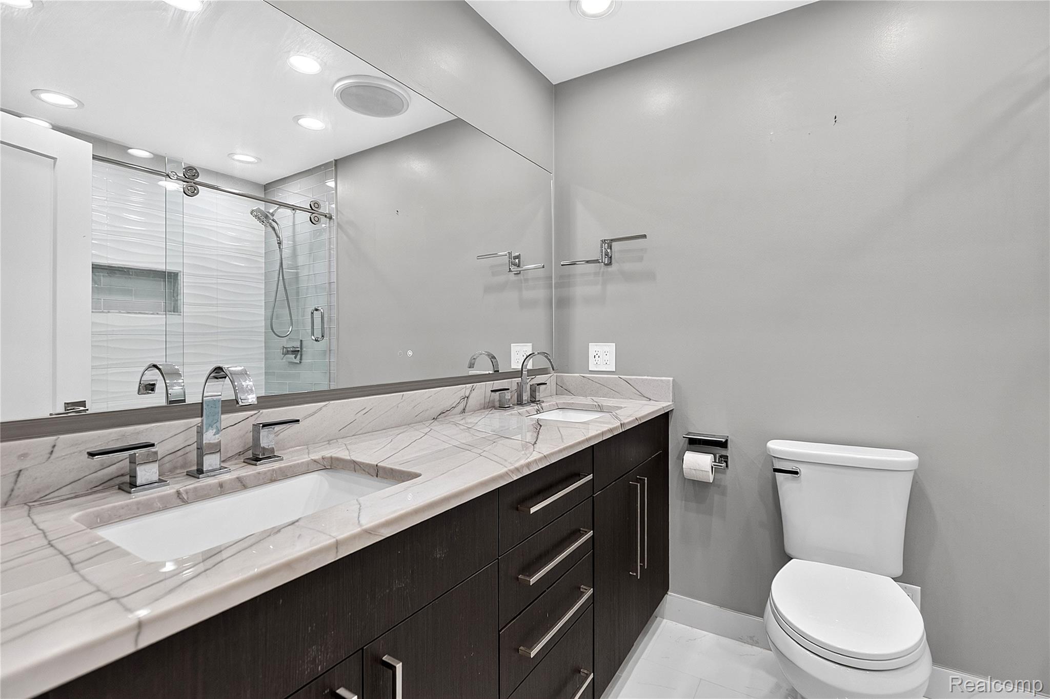 15879 Millar Road Clinton Township, MI 48036 - Photo 28 of 65 Double vanity with integrated sinks, chrome fixtures, dark wood-finish cabinetry, and a large wall-mounted mirror