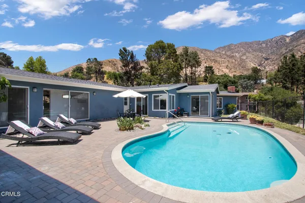 a view of a house with swimming pool and sitting area