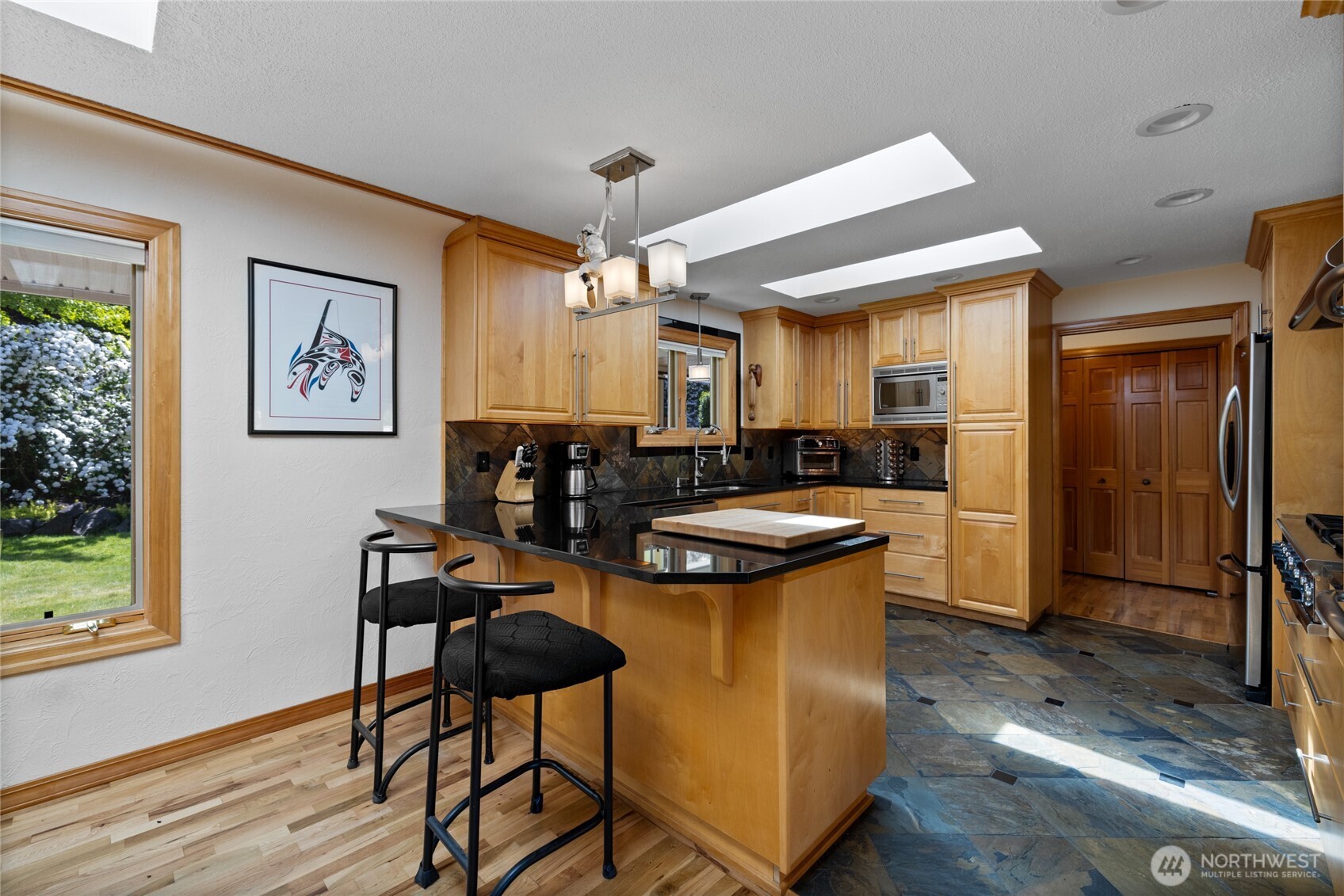 295 Southeast Bayview Road Shelton, WA 98584 - Photo 13 of 40 a kitchen with stainless steel appliances kitchen island granite countertop a table chairs and a refrigerator