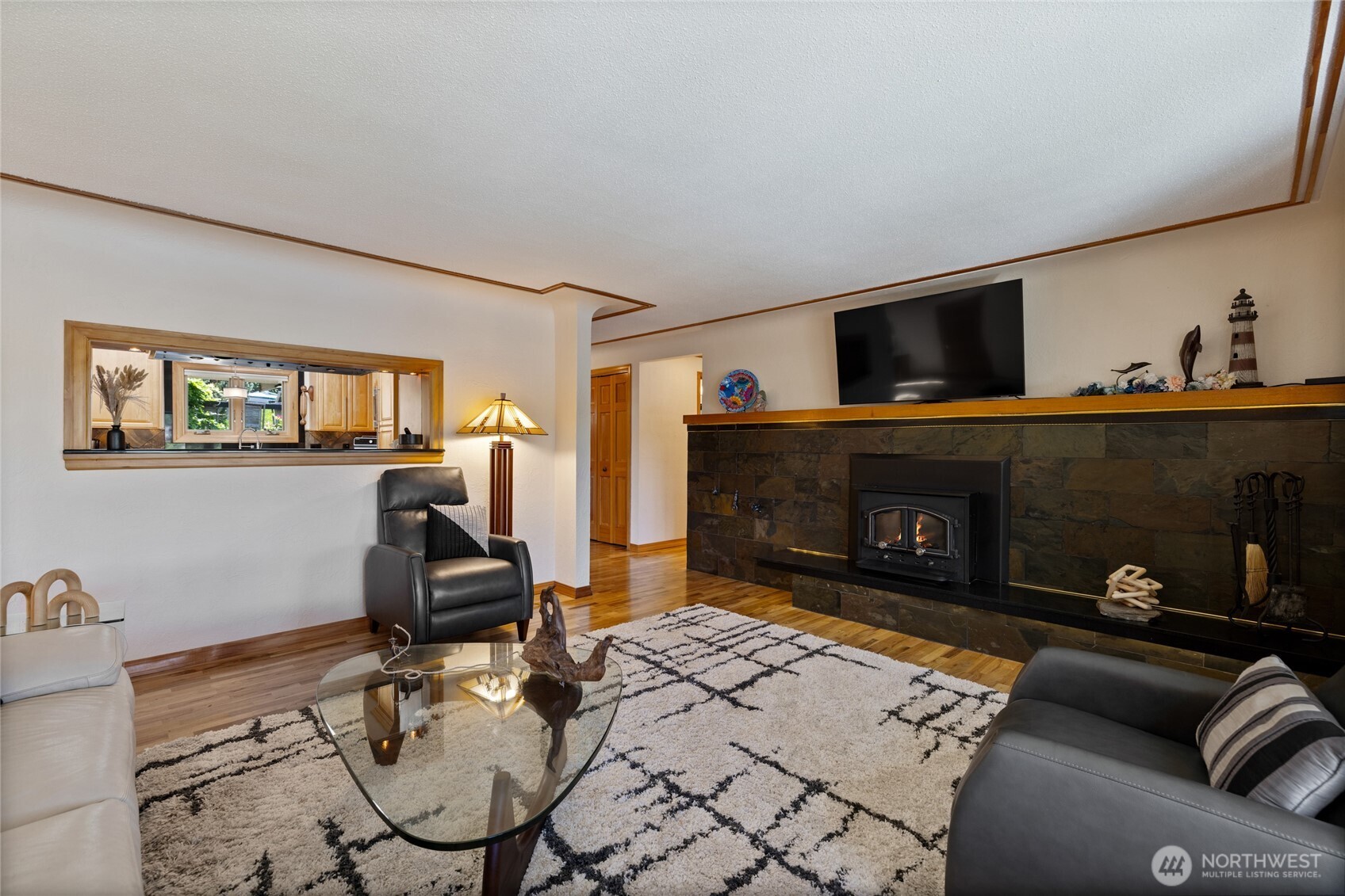 295 Southeast Bayview Road Shelton, WA 98584 - Photo 7 of 40 a living room with furniture a flat screen tv and a fireplace