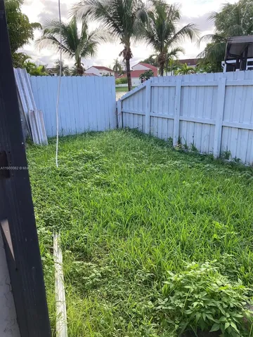 a view of a backyard with wooden fence