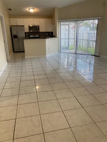 a kitchen with stainless steel appliances kitchen island granite countertop a refrigerator and a stove top oven