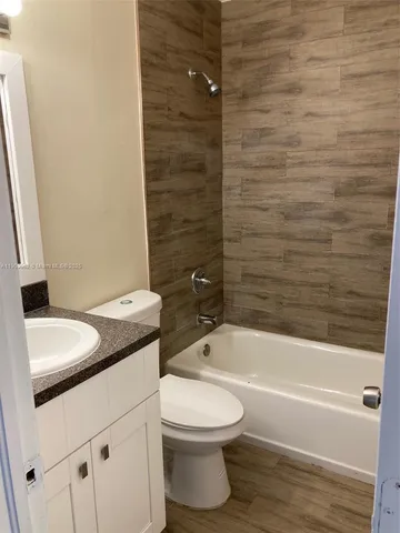 a bathroom with a granite countertop toilet a sink and bathtub