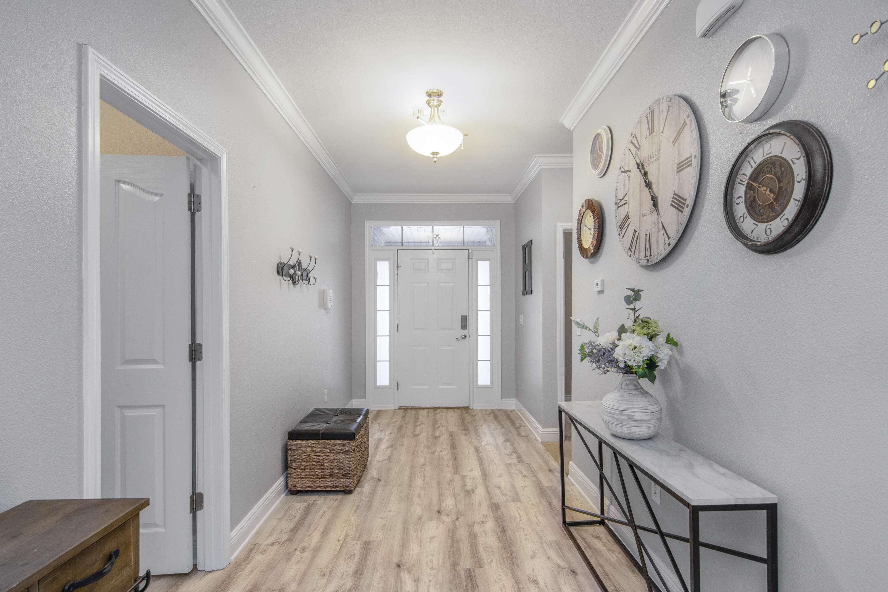 809 Yew Circle Crestview, FL 32536 - Photo 3 of 24 a hallway with wooden floor and a chandelier