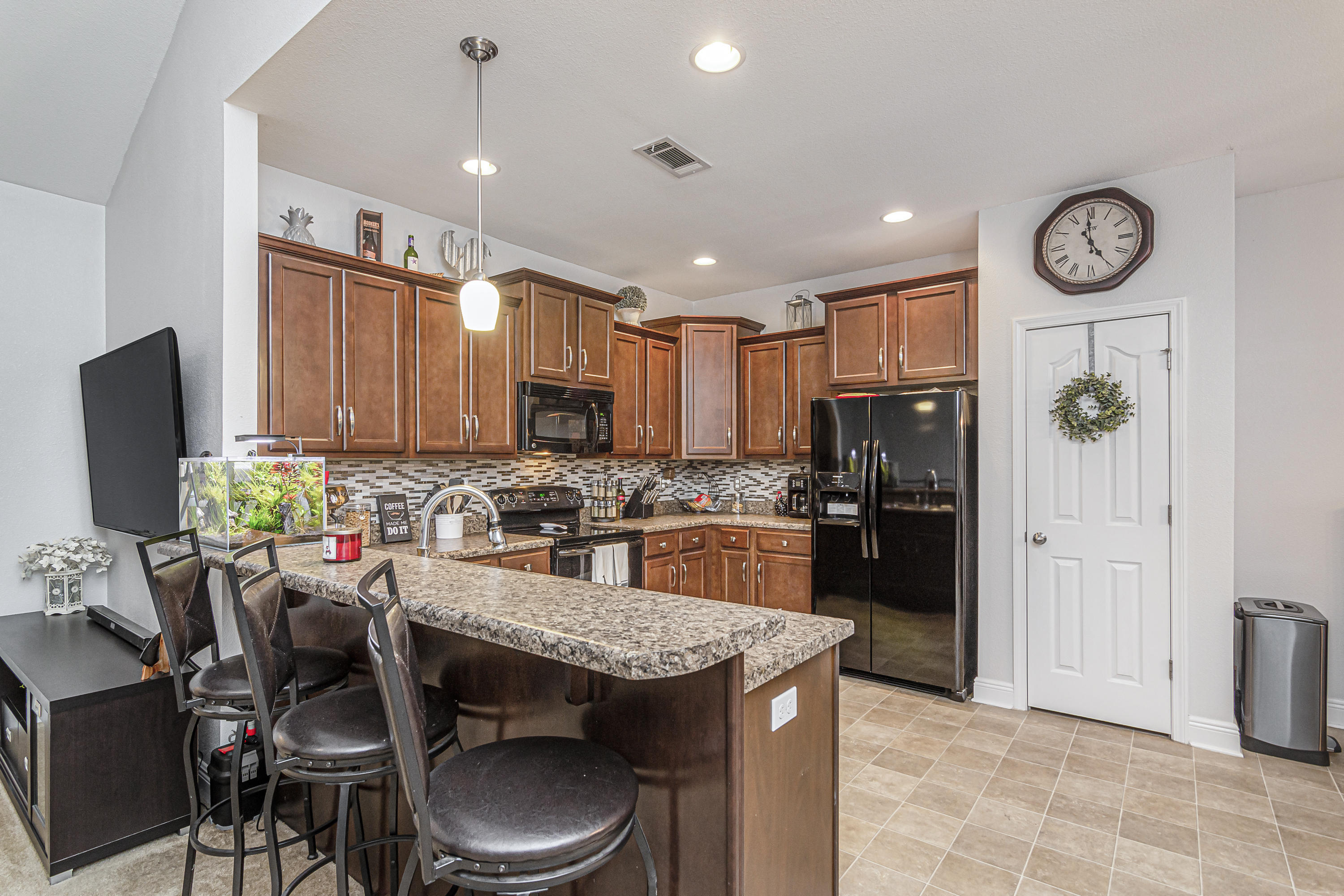 809 Yew Circle Crestview, FL 32536 - Photo 6 of 24 a kitchen with a refrigerator a stove top oven a sink and chairs