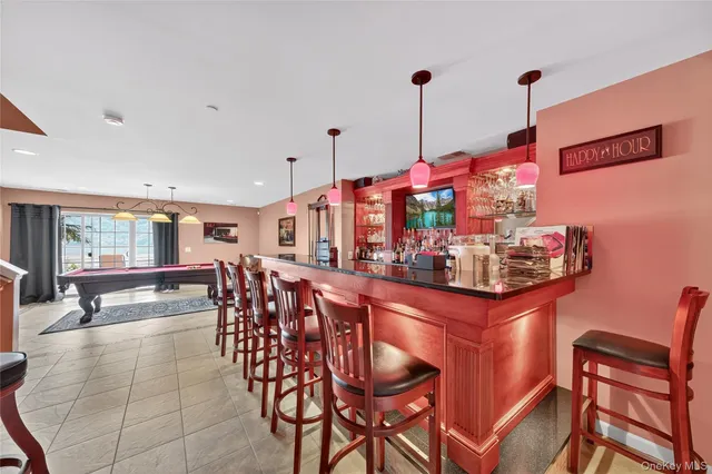 a dining hall with stainless steel appliances kitchen island granite countertop a table and chairs