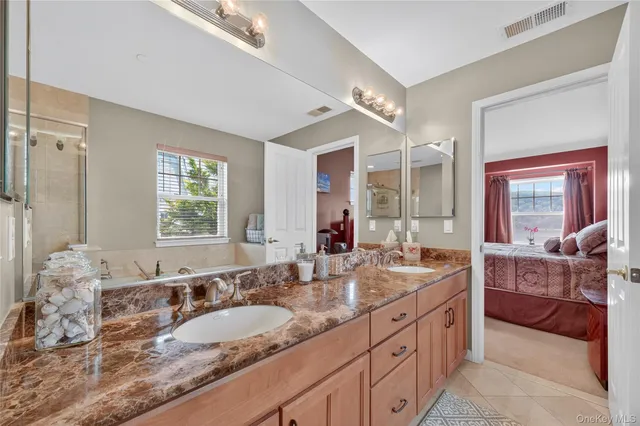 a bathroom with double vanity sinks double vanity tub shower and a mirror