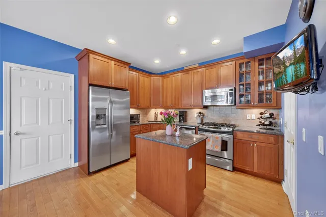 a kitchen with stainless steel appliances granite countertop a refrigerator stove top oven and sink