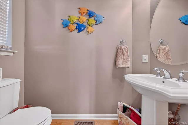 a bathroom with a sink mirror vanity and toilet