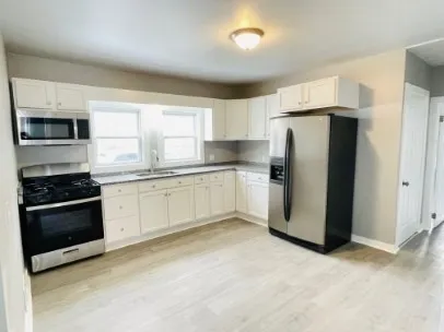 a kitchen with a refrigerator sink and stove top oven