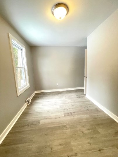 155 Oak Street, Unit 1 Taunton, MA 02780 - Photo 3 of 12 an empty room with wooden floor and windows