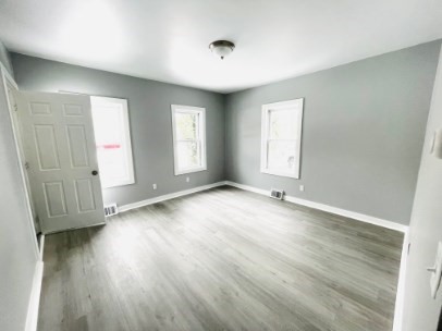155 Oak Street, Unit 1 Taunton, MA 02780 - Photo 4 of 12 an empty room with wooden floor and windows