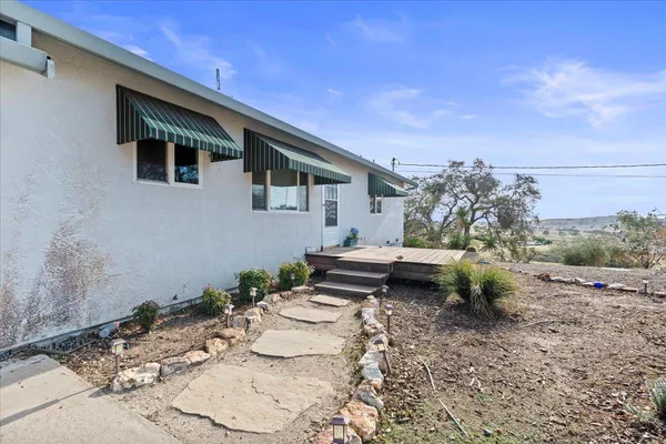 a backyard of a house with table and chairs