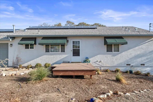 a view of a house with a roof and a yard