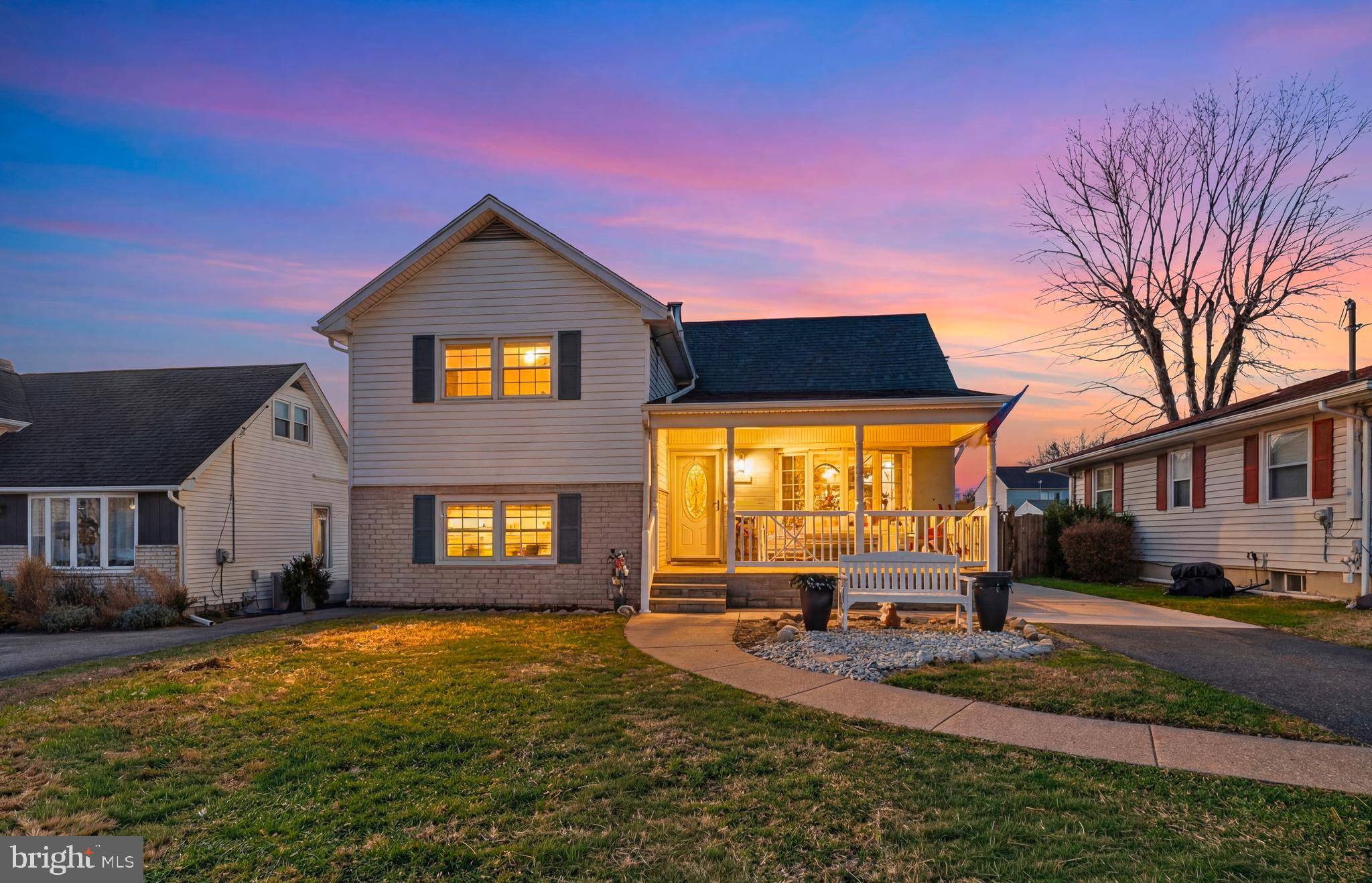 a front view of house with yard and trees in the background