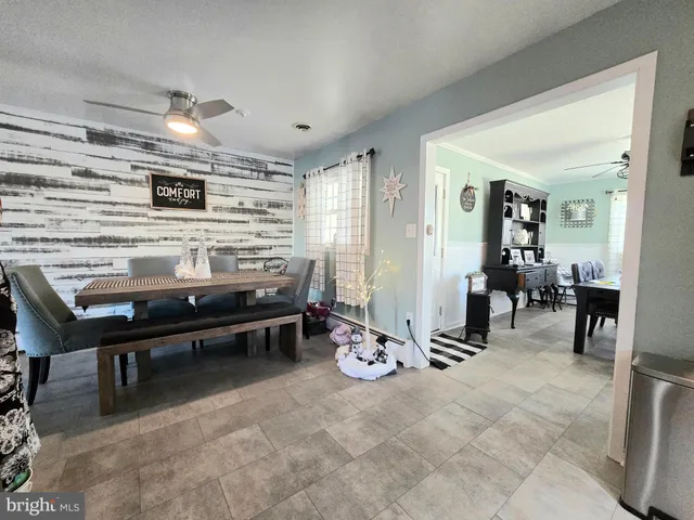 a view of a dining room with furniture a rug and wooden floor