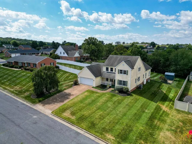 a view of a house with a big yard plants and large trees