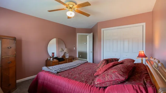 an empty room with a ceiling fan and carpet