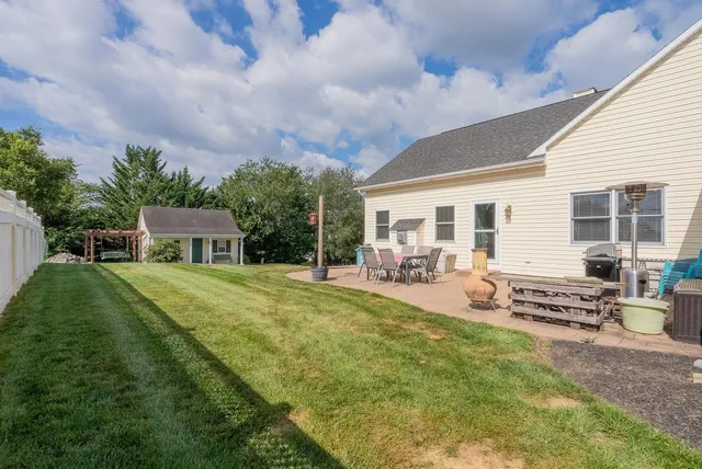 a view of a house with backyard and sitting area