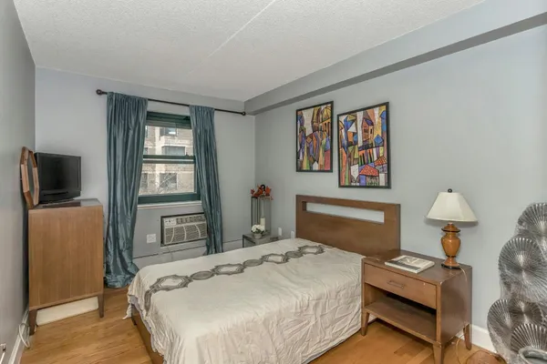 a bedroom with a bed and a lamp on dresser